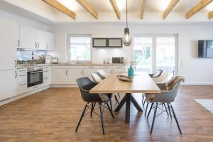 a kitchen with a wooden table and chairs at Fascherhus in Risum-Lindholm