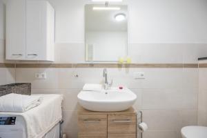 a white bathroom with a sink and a mirror at Utsicht in Halebüll