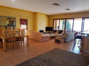 a living room with yellow walls and a table and chairs at Pecanwood Home Away from Home in Hartbeespoort