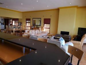a living room with a couch and a table at Pecanwood Home Away from Home in Hartbeespoort