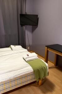 a bedroom with a bed and a desk and a television at Nätra Motell in Bjästa