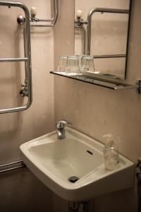 La salle de bains est pourvue d'un lavabo blanc et d'un miroir. dans l'établissement Nätra Motell, à Bjästa