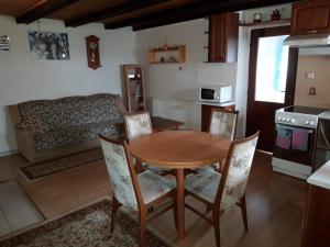 a kitchen with a table and chairs and a couch at Bungalov Mladé Buky in Mladé Buky