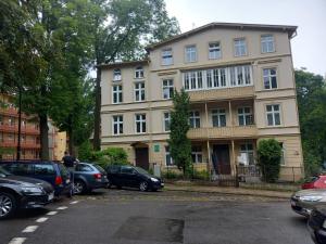 a large building with cars parked in front of it at Rooms Gdańsk Wrzeszcz centrum in Gdańsk
