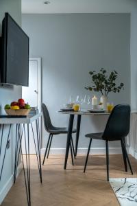 uma mesa de jantar com 2 cadeiras e uma televisão em Skyline Serviced Apartments - Flat A Rockingham Way em Stevenage