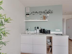 a white kitchen with white cabinets and a sink at limehome Darmstadt Wilhelminenstraße - Digital Access in Darmstadt