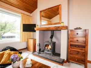 ein Wohnzimmer mit Kamin in einem Haus in der Unterkunft Maesteg - Llanberis in Caernarfon