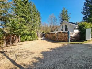 a house with a fence next to a yard at Chalet Cato in Durbuy +6 photos
