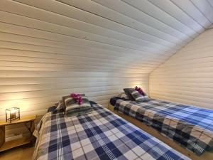 two beds in a room with white walls at Chalet Cato in Durbuy