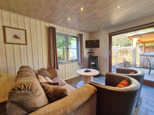 a living room with a couch and chairs and a table at Chalet Cato in Durbuy