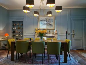 a dining room with a table and green chairs at CHATEAU DE BRINVILLE in Saint-Sauveur-sur-École