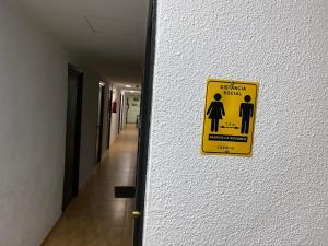 un panneau jaune sur le mur d'un couloir dans l'établissement PENSIÓN ROSA, à Benidorm