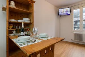 a kitchen with a wooden counter with plates and wine glasses at Appartement Paccard 305 - Happy Rentals in Chamonix