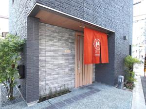 una bandera roja está colgando en el costado de un edificio en ShukuShuku en Kioto