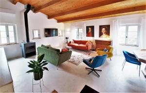 a living room with a couch and chairs and a tv at Un je ne sais quoi de Paradis in Les Vans