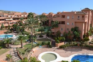 an aerial view of a resort with two pools and palm trees at Apartementos Almerimar Golf in Almerimar