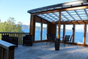 a screened in deck with a table and chairs at Hjelvikhytta - flott beliggenhet ved sjøen in Hjelvik