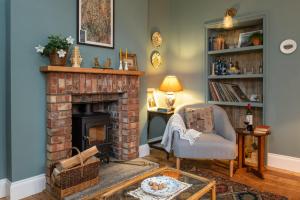 a living room with a brick fireplace and a chair at Finest Retreats - North Lodge in Cockermouth