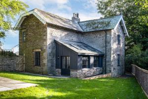 an old brick house with a green yard at Finest Retreats - North Lodge in Cockermouth