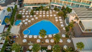 an overhead view of a resort pool with umbrellas and chairs at Vrissaki Beach Hotel in Protaras