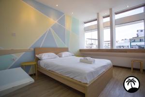 Schlafzimmer mit einem Bett mit weißer Bettwäsche und Fenstern in der Unterkunft Paradise Suite at Asiacity in Kota Kinabalu