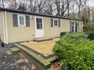 une petite maison avec une porte d'entrée et une cour dans l'établissement Chalet Togo, à Wageningue