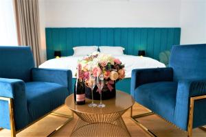 a room with a bed and a table with a bouquet of flowers at Hotel Glory in Oradea