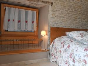 um quarto com uma cama e uma janela em Les Grands Prés em Geney