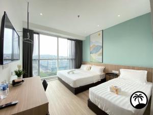 Una habitación de hotel con dos camas y un escritorio. en Paradise Suite at Sutera Avenue, en Kota Kinabalu