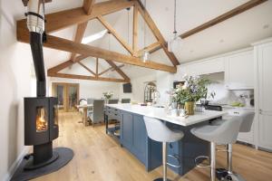a kitchen with a fireplace and a kitchen with white cabinets at The Cowshed in Brent Knoll