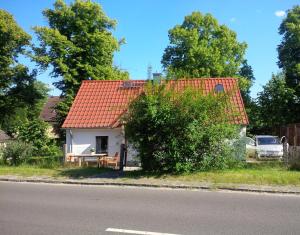 ein kleines weißes Haus mit orangefarbenem Dach in der Unterkunft Villa Fröhlich in Straupitz