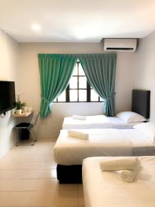 a hotel room with three beds and a window at HAKO XPRESS TMN SKUDAI BARU in Skudai