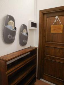 a pair of shoes hanging on a wall next to a dresser at Le Camere della Piazza in Rigoso