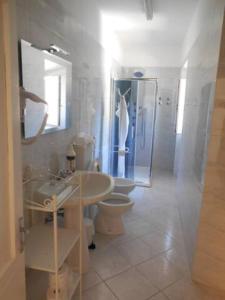 a bathroom with two toilets and a sink and a shower at Le Camere della Piazza in Rigoso
