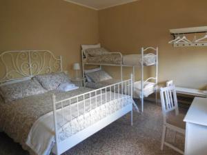 a bedroom with two bunk beds and a desk at Le Camere della Piazza in Rigoso
