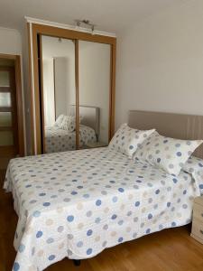 sypialnia z łóżkiem i dużym lustrem w obiekcie Piso Vista os castelos w mieście Viveiro