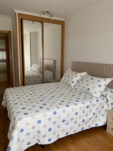 1 dormitorio con cama y espejo grande en Piso Vista os castelos, en Viveiro