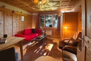 ein Wohnzimmer mit einem roten Sofa und einem Tisch in der Unterkunft Flumserberg in Flumserberg