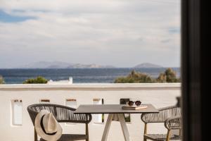 een tafel en stoelen op een balkon met uitzicht bij Ostria Inn in Moutsoúna