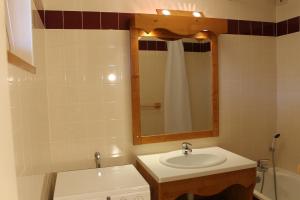 een badkamer met een wastafel en een spiegel bij Résidence Saboia B54 Clés Blanches Courchevel in La Tania