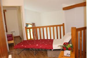 een slaapkamer met een bank met een rood en wit kussen bij Résidence Saboia B54 Clés Blanches Courchevel in La Tania