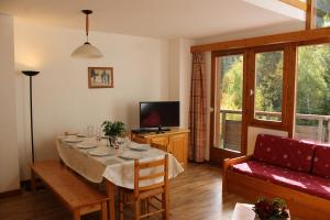 een woonkamer met een tafel en een bank bij Résidence Saboia B54 Clés Blanches Courchevel in La Tania