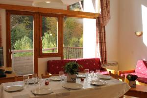 een eetkamer met een tafel en een groot raam bij Résidence Saboia B54 Clés Blanches Courchevel in La Tania +6 foto's