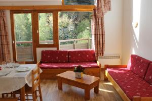 een woonkamer met rode banken en een tafel bij Résidence Saboia B54 Clés Blanches Courchevel in La Tania