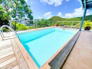 una piscina en un patio con una montaña en el fondo en Villa Casa Blue, between sky and ocean, Almond Grove en Koolbaai
