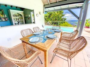 comedor con mesa y sillas en Villa Casa Blue, between sky and ocean, Almond Grove en Koolbaai