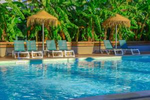 a group of chairs and umbrellas next to a swimming pool at Bayside Salgados in Albufeira