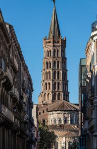 een hoge toren met een toren bovenop een gebouw bij Residence le Pastel Jeanne d'Arc in Toulouse
