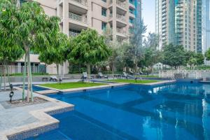 une grande piscine avec des arbres et des bâtiments dans l'établissement BellaVista - Sophisticated - 2 BR - 29 Boulevard - Burj Khalifa & Fountain View, à Dubaï