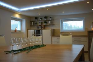 a kitchen with a wooden table with wine glasses on it at Vinařství Novotný in Čejkovice